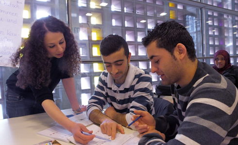 Lehrerin Yasemin Temizkan hilft zwei Schülern bei einer Partnerarbeit in der Klasse.